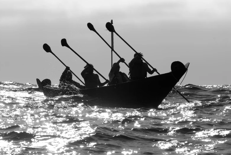 a group of people riding in a boat with oars