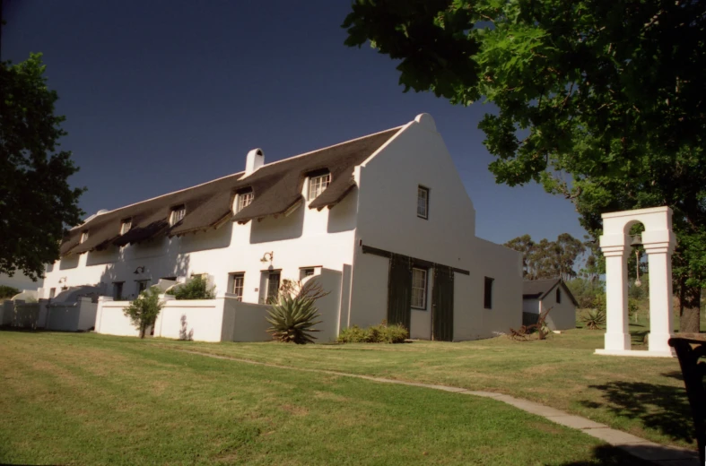 an white house with multiple windows, and a large front yard