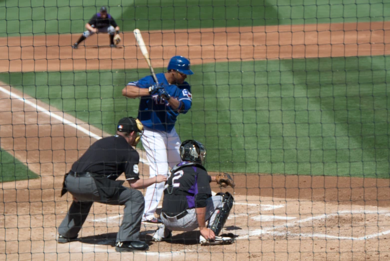 baseball player holding a bat on home plate