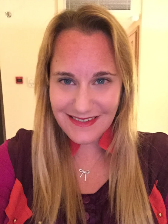 a woman wearing a red and white shirt with a silver and red necklace