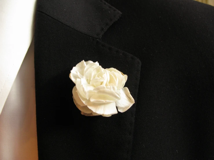 a white flower on a black suit jacket