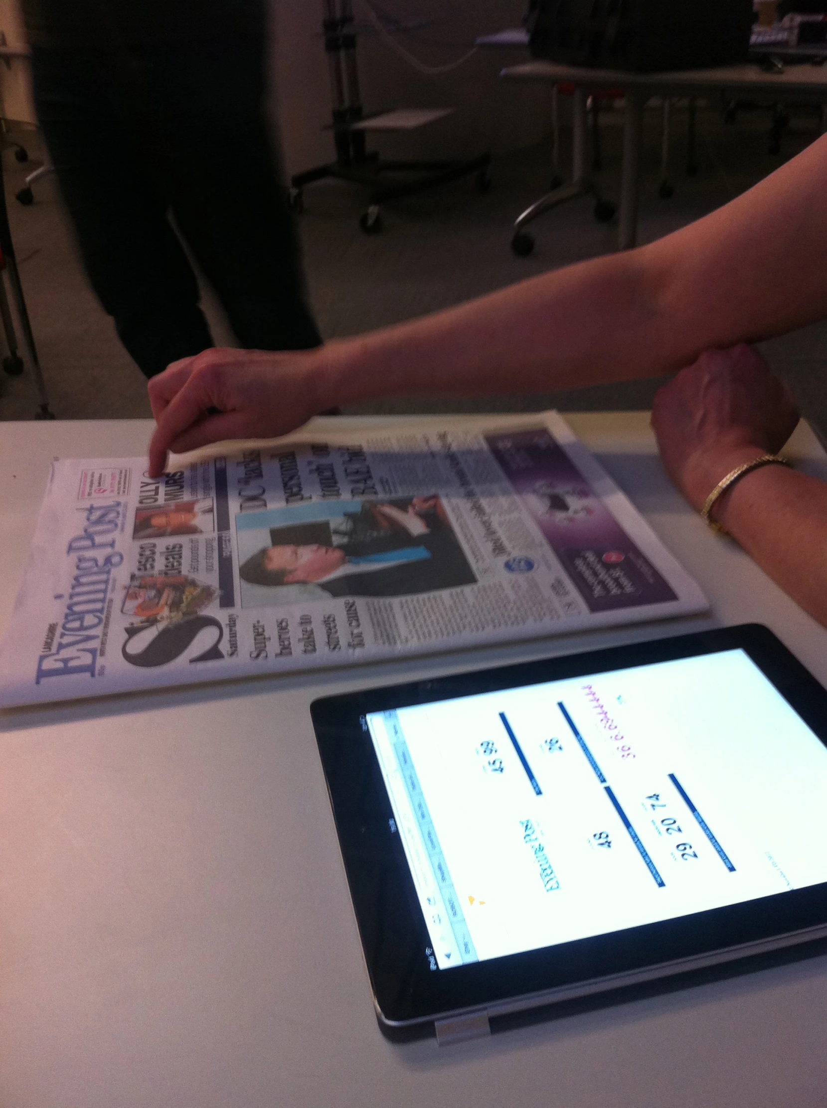 a table with a tablet on top of it next to a magazine