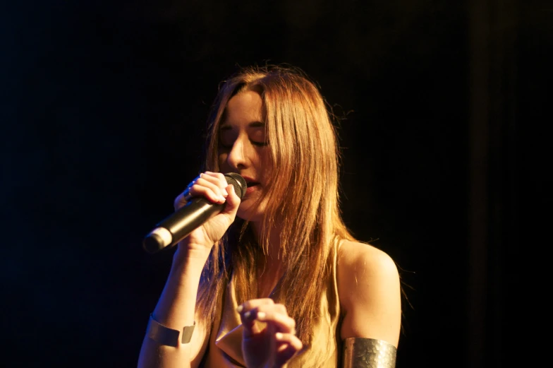 a young woman holding a microphone on stage