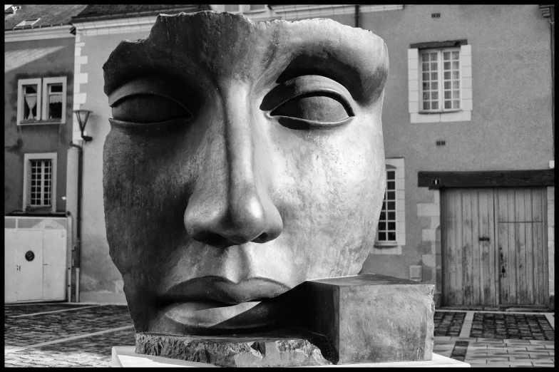 a face carved from concrete with a block on the side