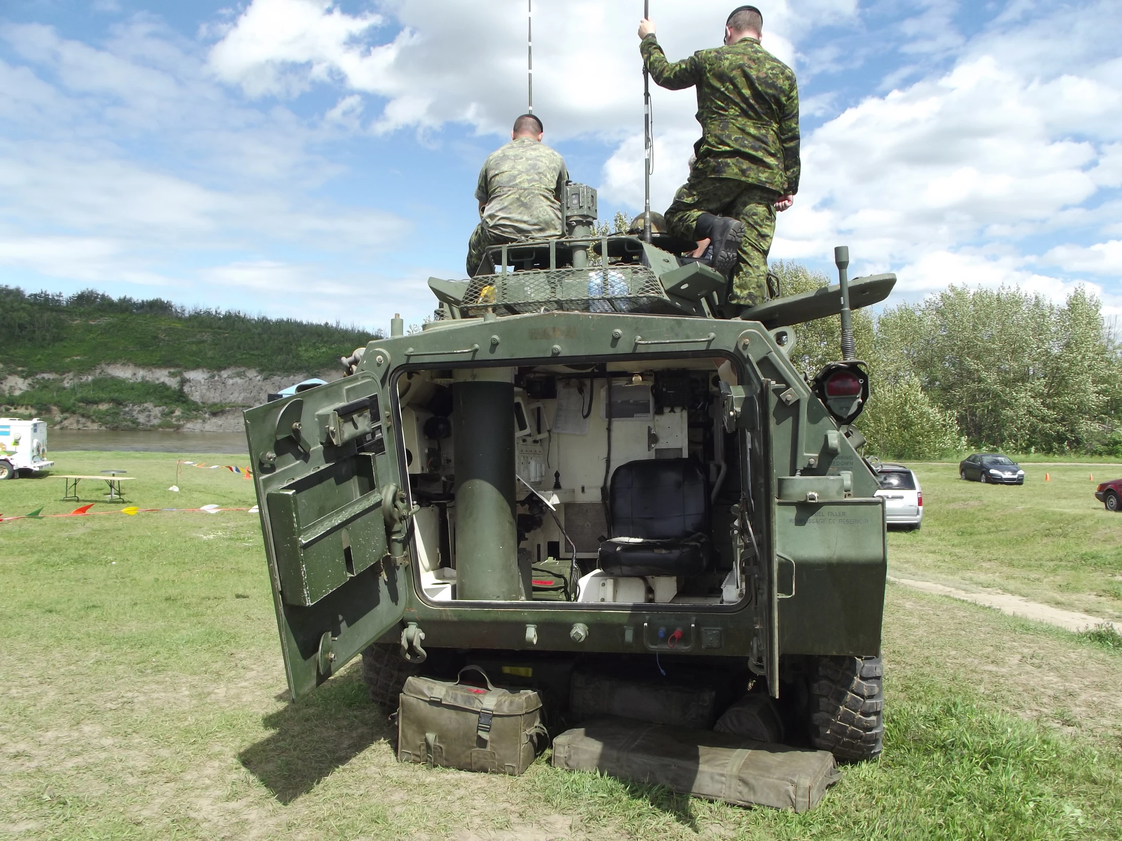 two soldiers on top of a military vehicle