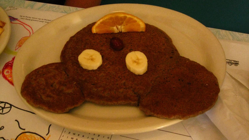 a plate with pancakes on it that has an apple cut out of the face