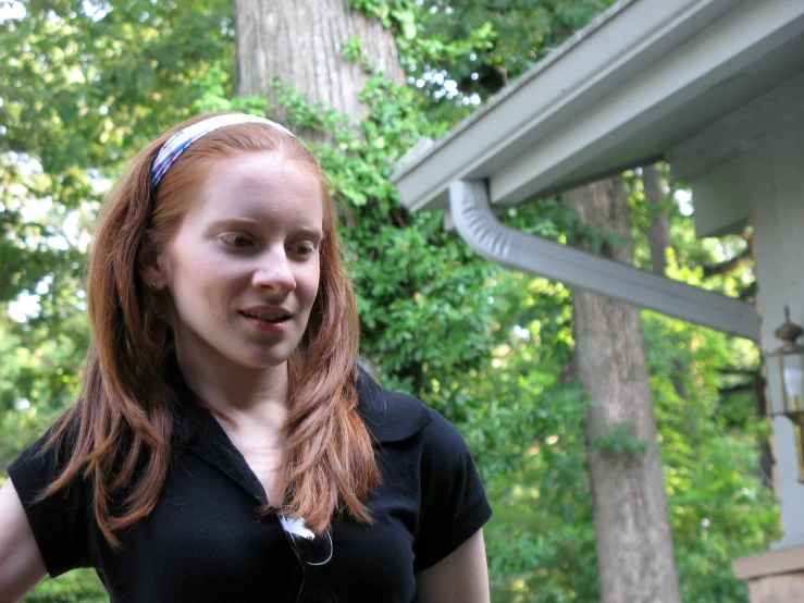 a girl is wearing an earband in the park