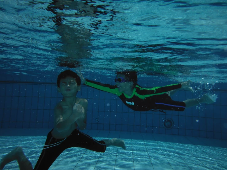 a man and woman are in the pool underwater