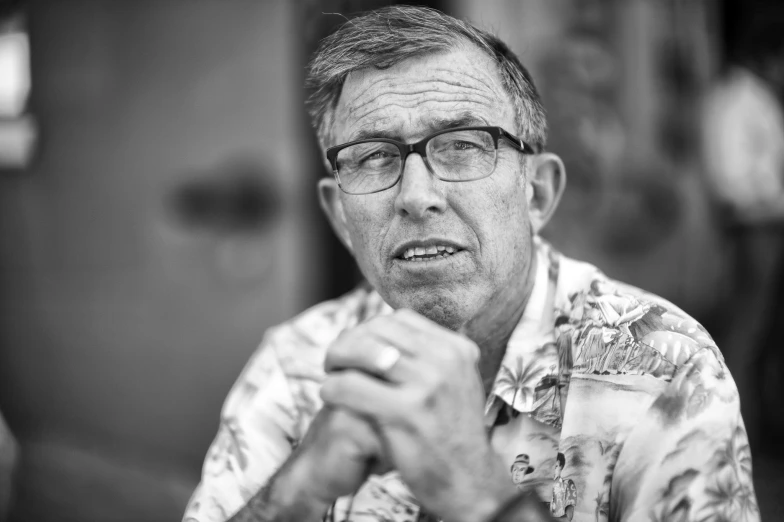 a man wearing glasses and a shirt with a floral design on it