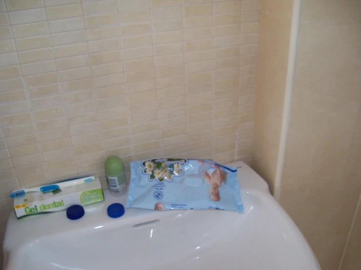 a white sink sitting next to a brown tiled wall