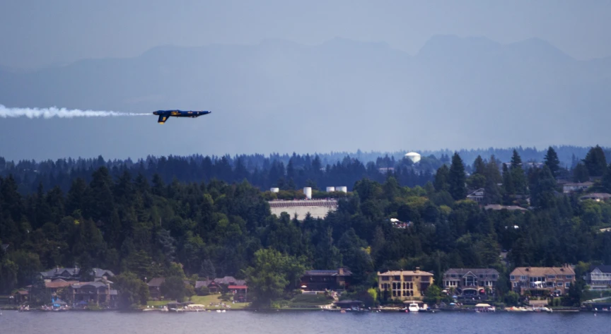 an airplane flying over a river in a small town