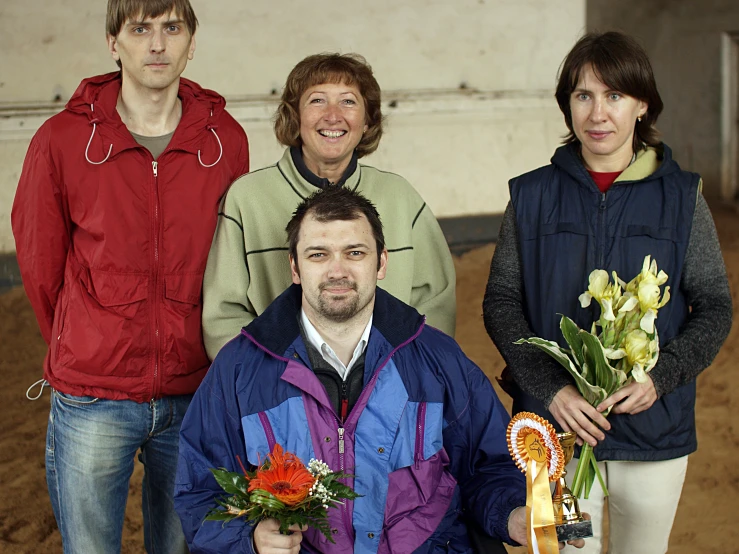 a group of people posing with a woman holding flowers