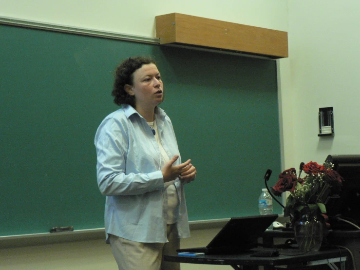 a woman standing next to a table holding a microphone