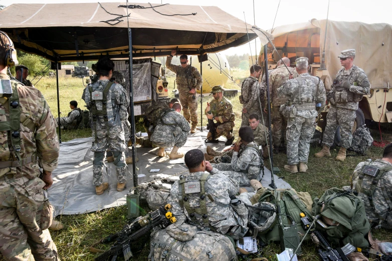 a group of men in camouflage sitting next to each other