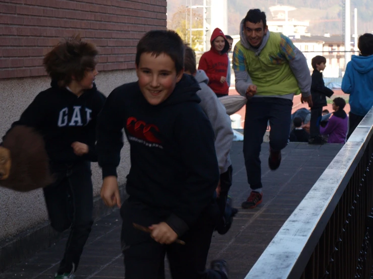 a group of young people walking down a walkway next to a tall building