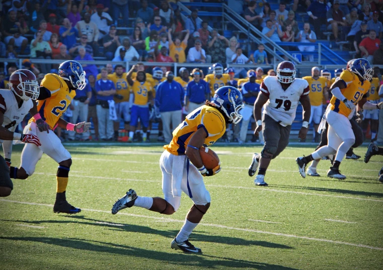 a group of men running down a football field