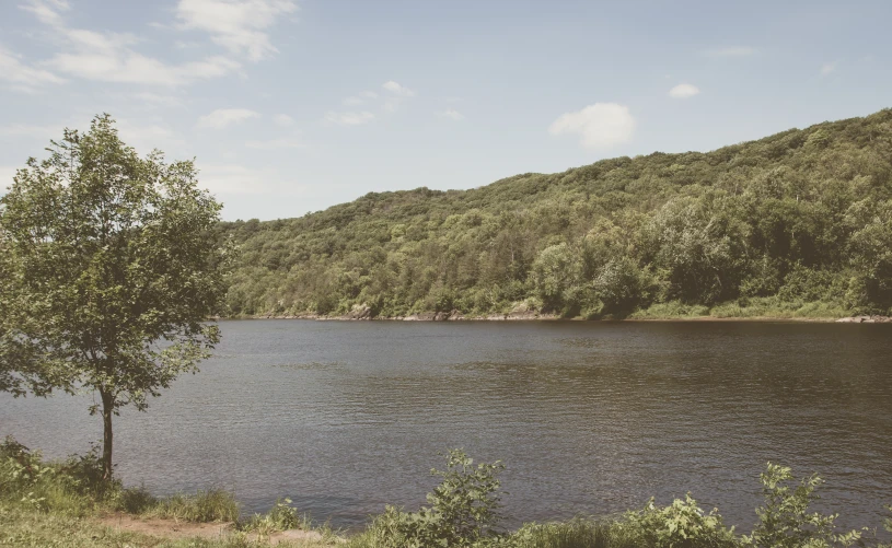 a beautiful lake with some trees along the shore