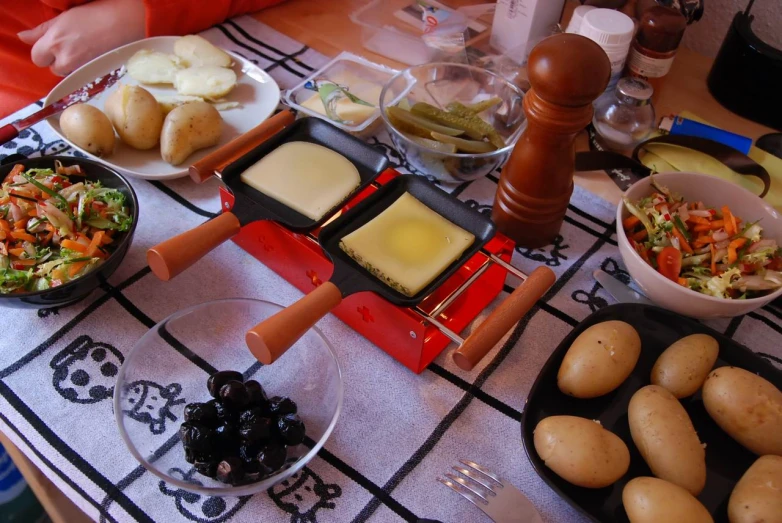 a table covered with plates and bowls with food