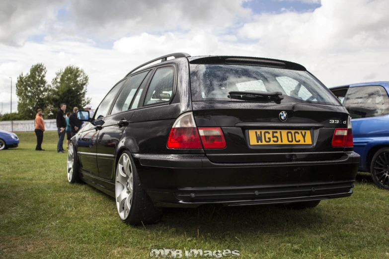 the front end of a black bmw car parked in the grass