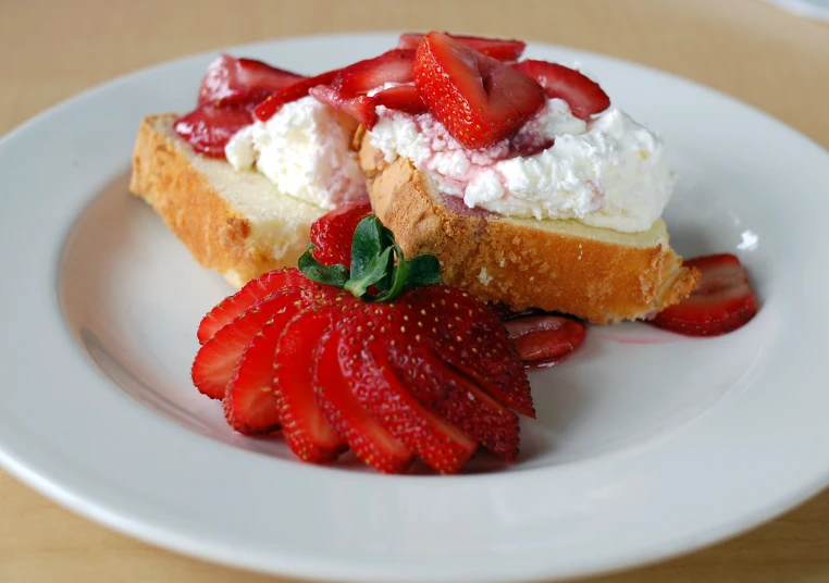 a piece of cake and two sliced strawberries on a plate