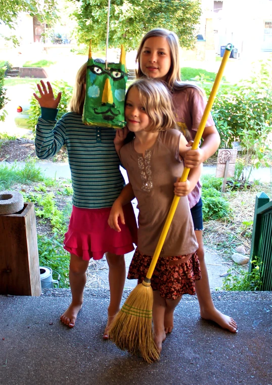 two little girls with brooms posing for the camera