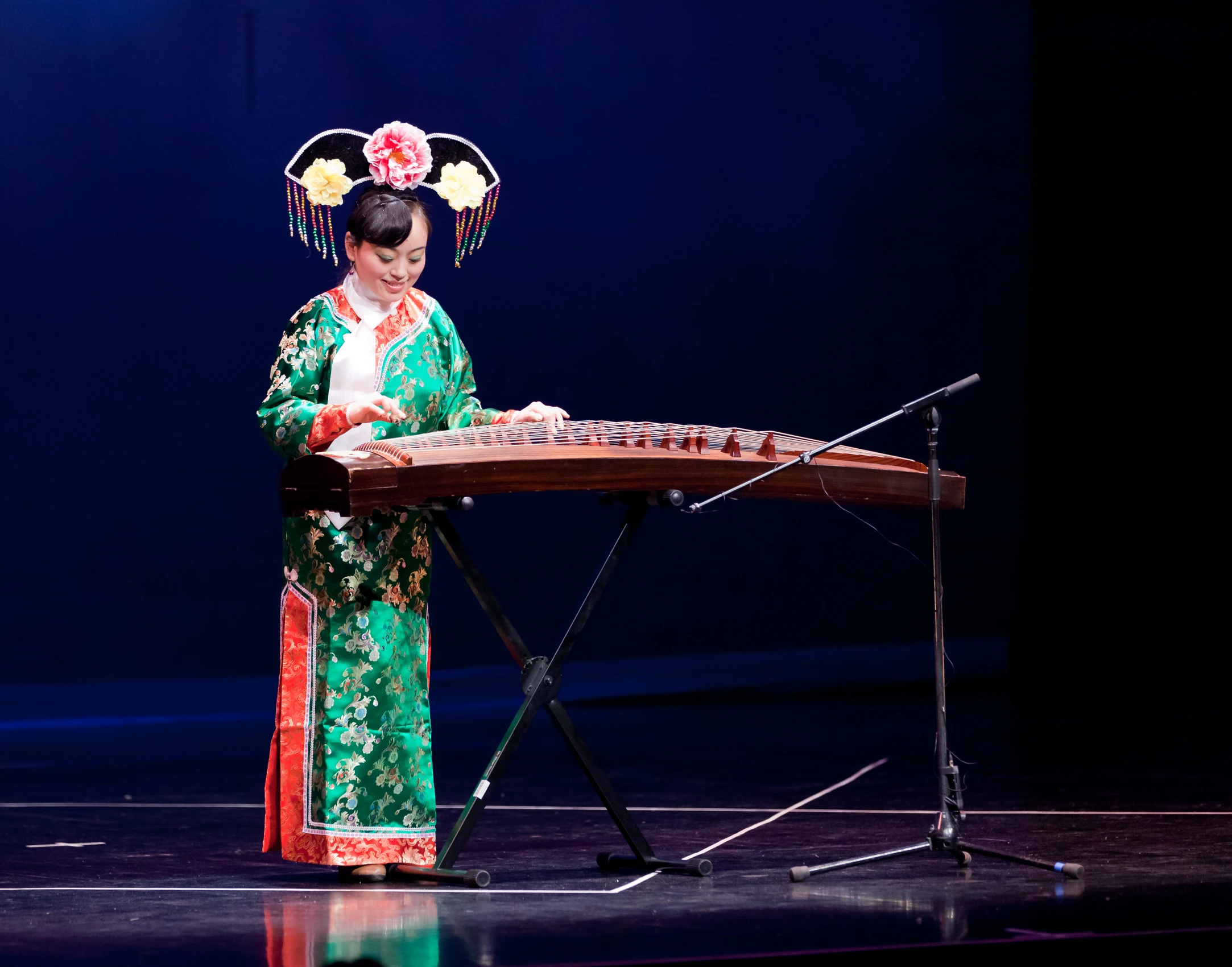 a geisha playing the traditional musical instrument on stage