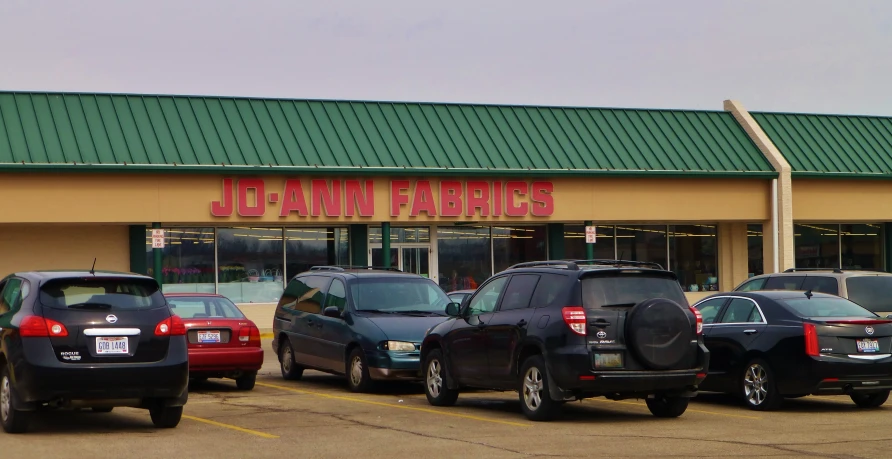 a group of cars parked in front of a large jca - nami farriger