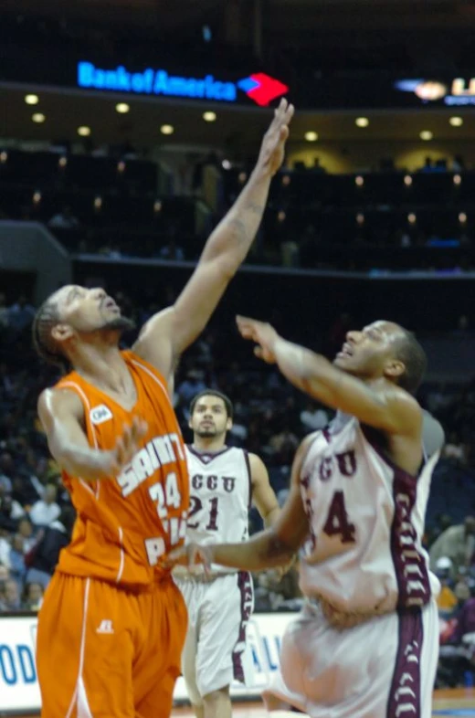 a group of men playing basketball against each other