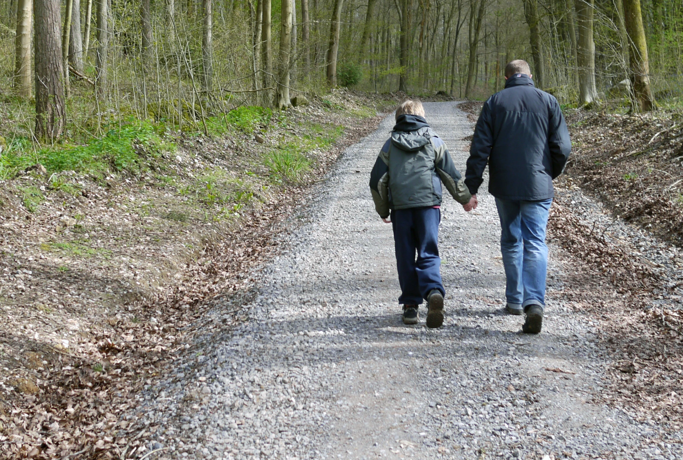 a man and woman walking on the road holding hands