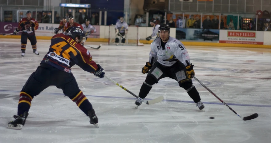 two men play on ice hockey during a game