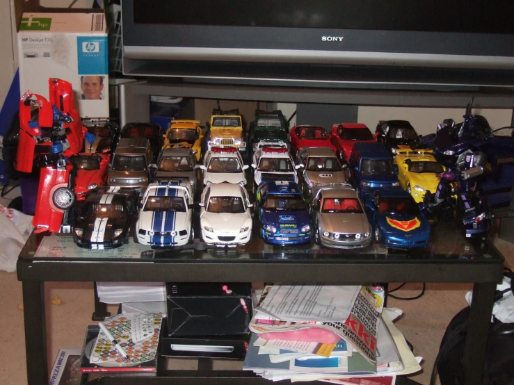 a variety of toy cars on display by the television