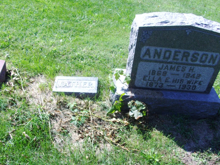 headstones placed in the grass near a grave