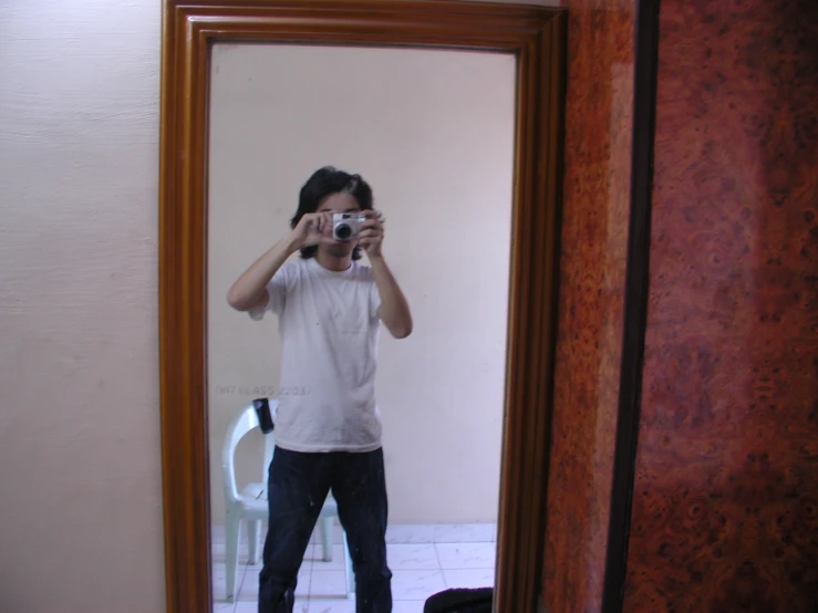 a man taking his own picture in the bathroom mirror