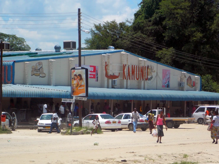 cars parked in front of the store where the vendors are selling their ware