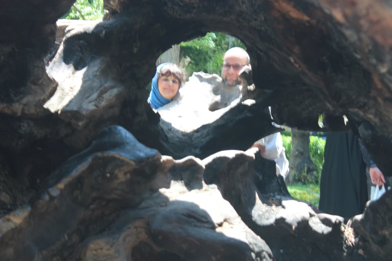 two people standing inside of a hollow in the ground