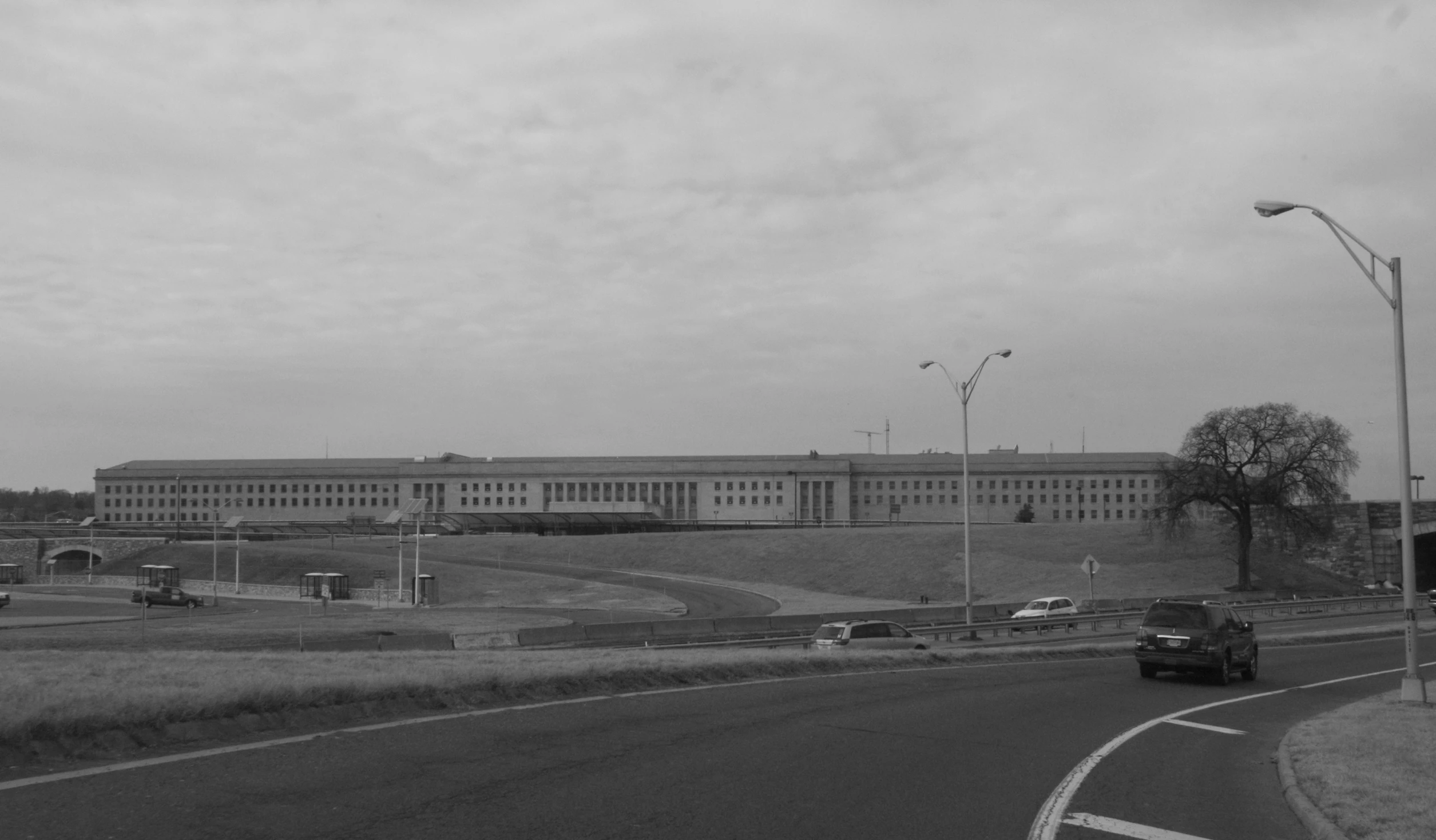 cars and buses driving in a line near a freeway