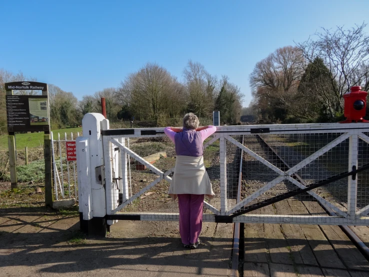 the person is walking towards a gate with signs