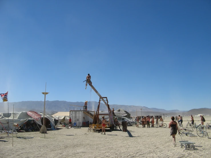 people are standing around on the beach