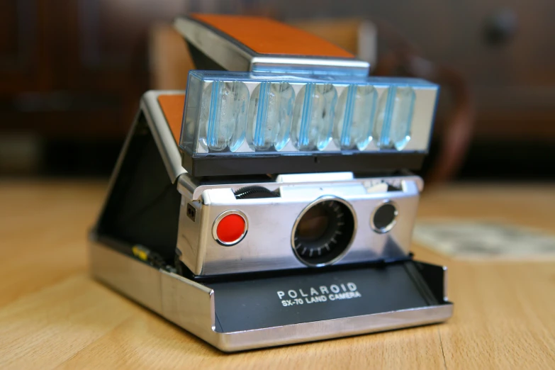 a polaroid camera sitting on top of a wooden table