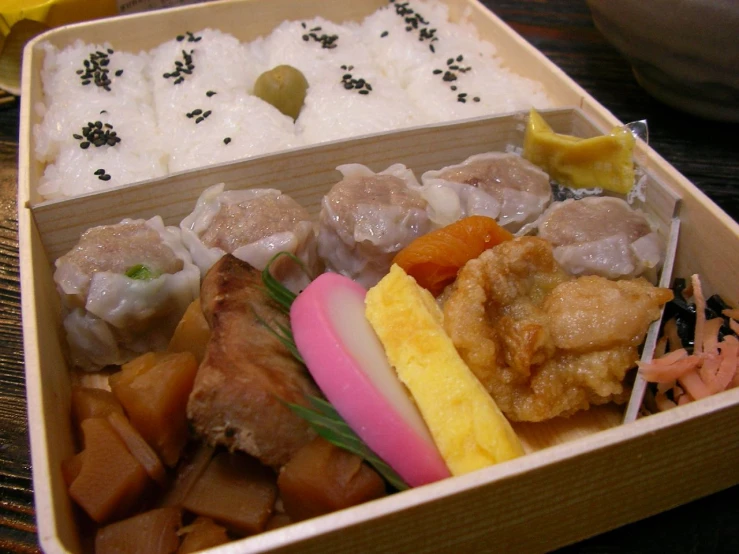 this box contains food like dumplings, rice and sauces