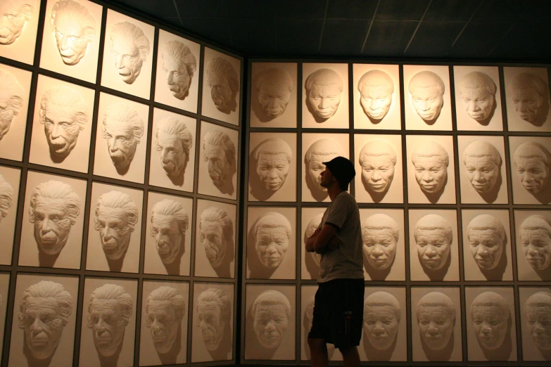 a person standing in front of a wall with various pictures