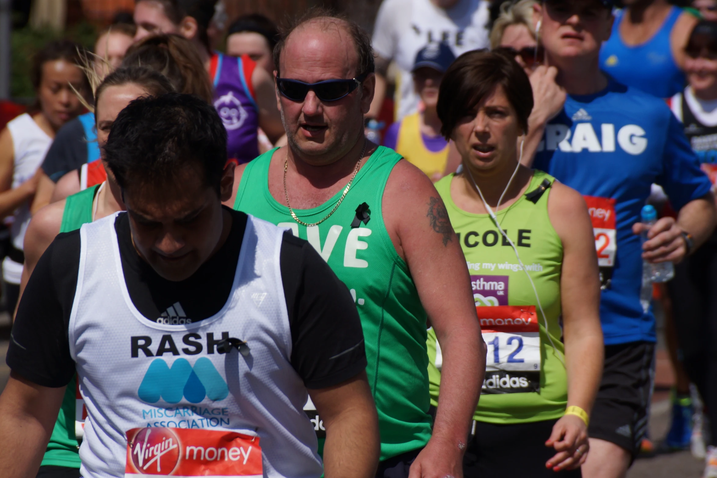 a man wearing a tank top in the middle of a race