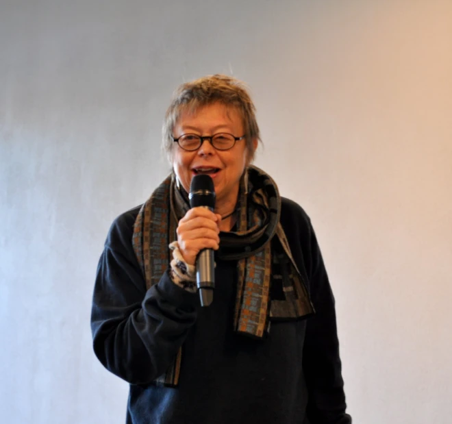 an older woman holding a microphone in front of her