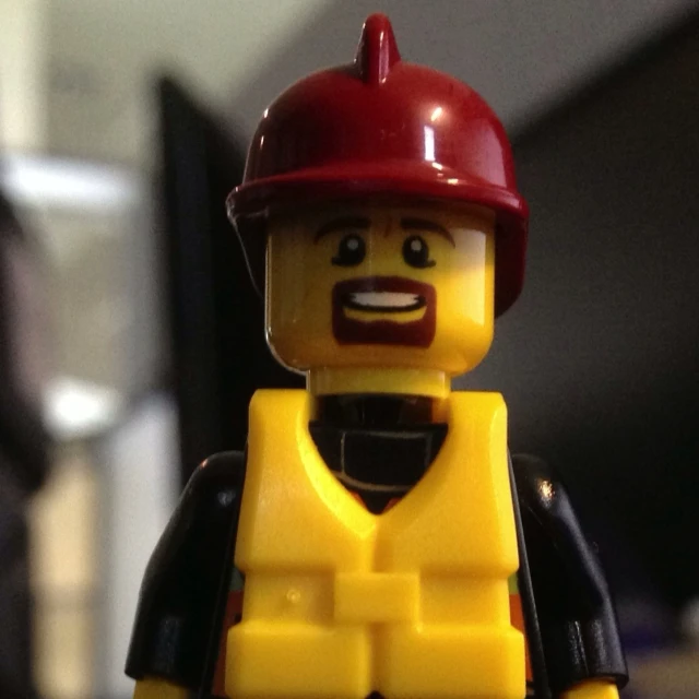 a yellow lego man wearing a red hard hat