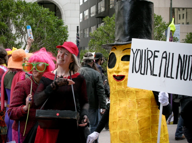 some women in costume stand around near a sign