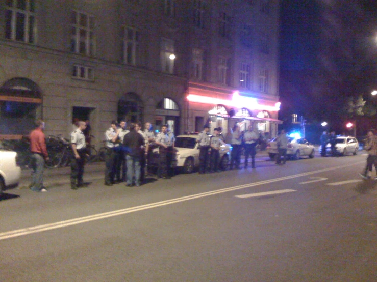 police officers standing around outside on the side of a road