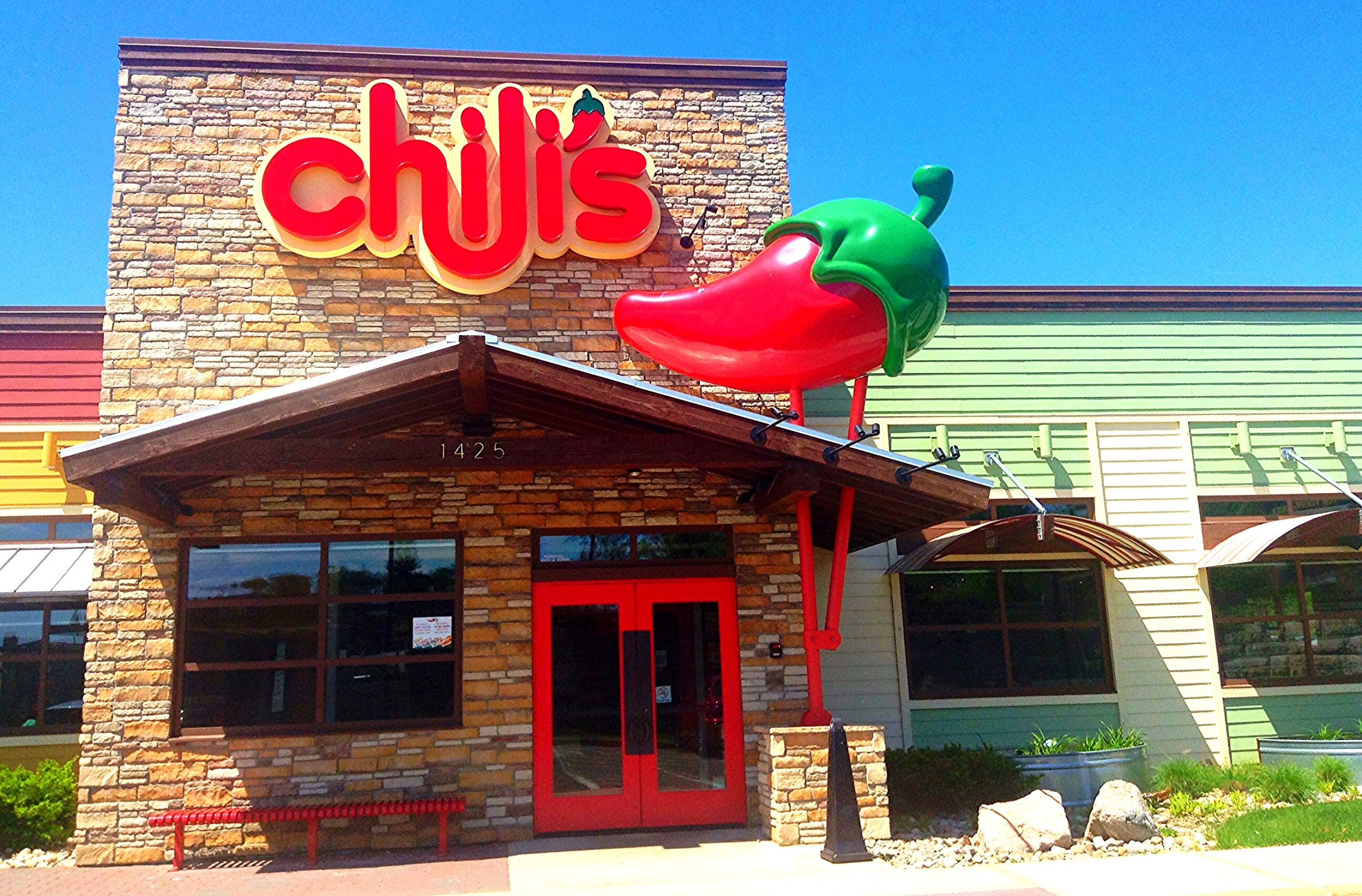 a large red chili and a big green pepper on top of the building