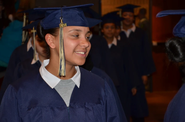 a  dressed in graduation clothes and holding soing