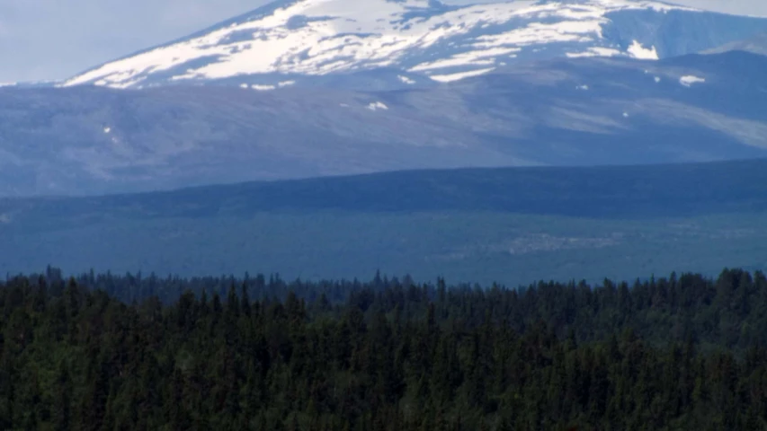 the mountains are covered in snow and trees