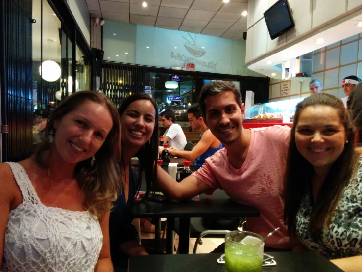 five people are smiling in front of the camera in a restaurant